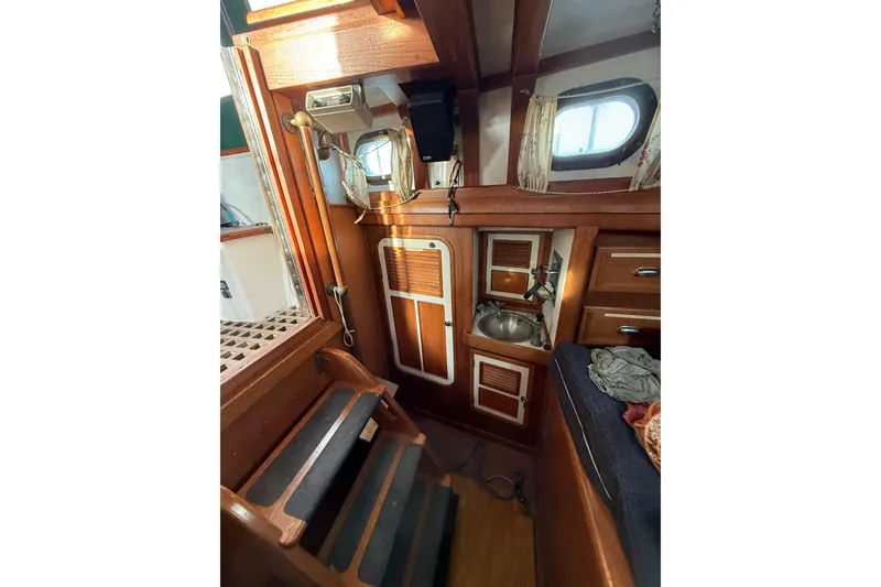 Slide: The Image of Interior of a 1990 Custom 46 boat with wooden cabinetry and compact sink area. - 23
