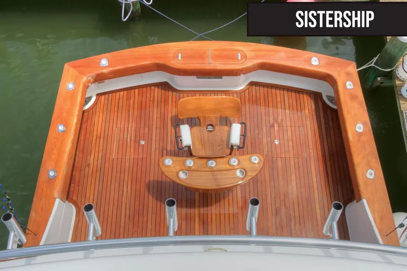 Slide: The Image of 2026 Titan Yachts sportfish deck with polished wood finish and fishing chair. - 7