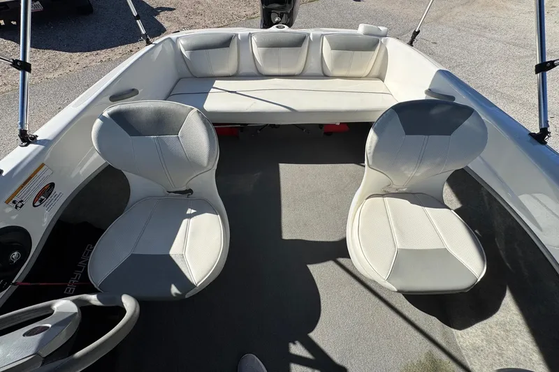 Slide: The Image of 2013 Bayliner 160 Bowrider interior with white seating and steering wheel. - 10