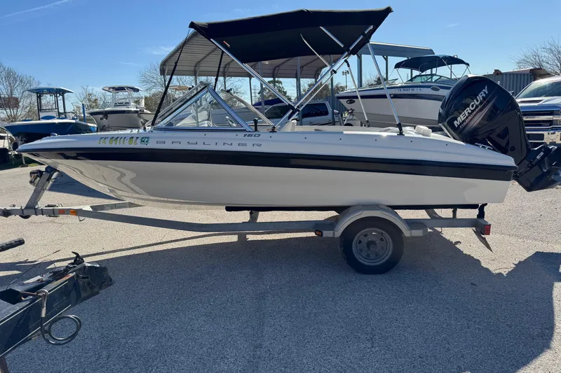 Slide: The Image of 2013 Bayliner 160 Bowrider boat on trailer with Mercury outboard engine. - 13