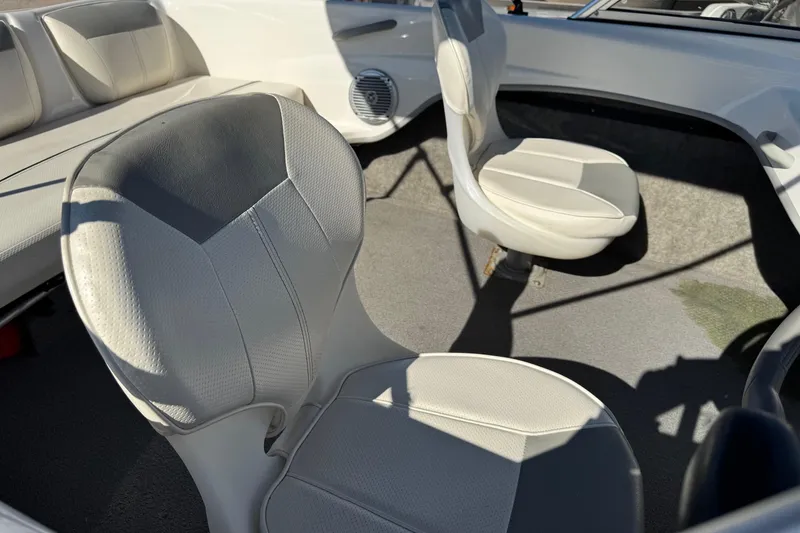 Slide: The Image of 2013 Bayliner 160 Bowrider interior with white seating and carpeted floor. - 9
