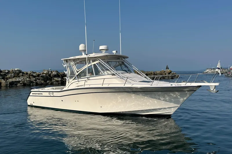 The Image of 2008 Grady White Express boat on calm water near rocky shoreline. - 0