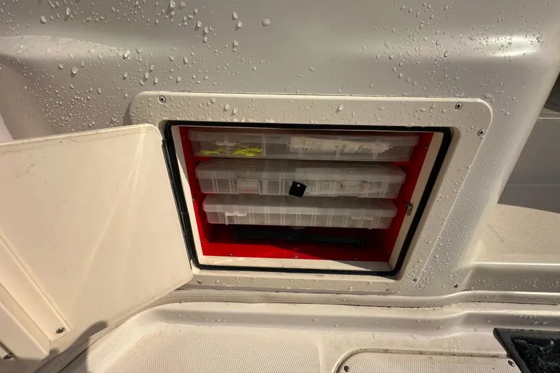 Slide: The Image of Storage compartment on a 2008 Grady White Express boat with organized tackle boxes. - 13