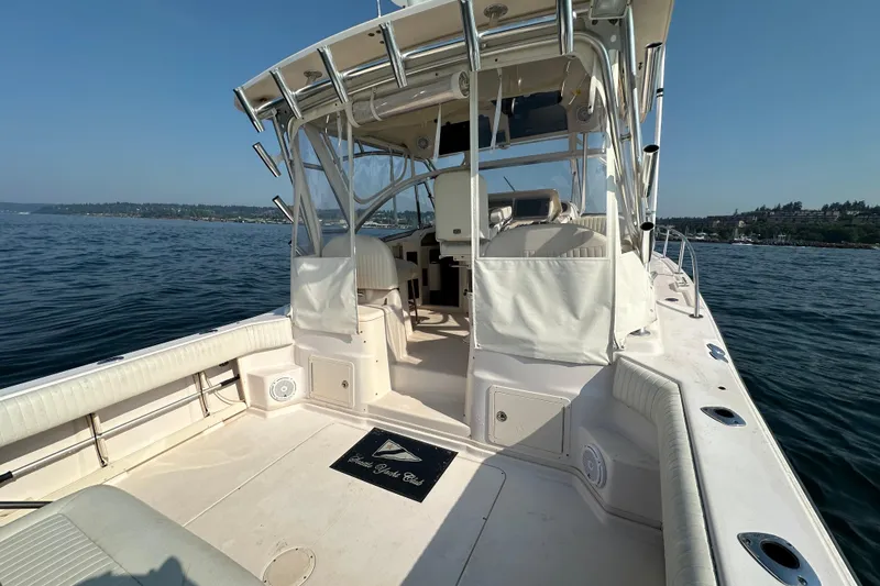Slide: The Image of 2008 Grady White Express boat on calm water, featuring spacious deck and seating. - 14