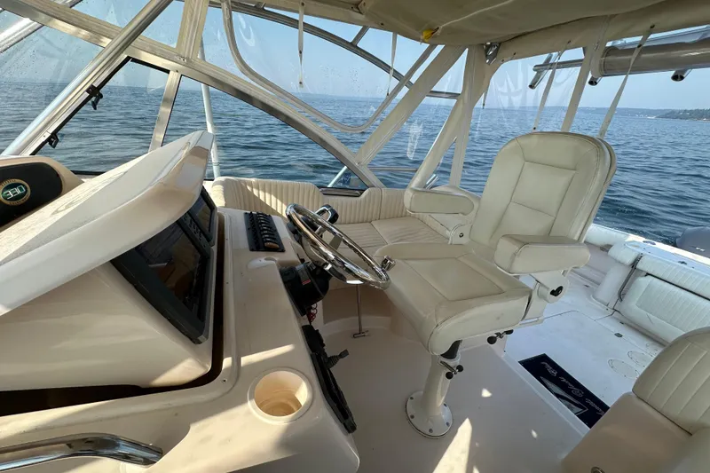 Slide: The Image of 2008 Grady White Express boat interior with helm, steering wheel, and seating on open water. - 21