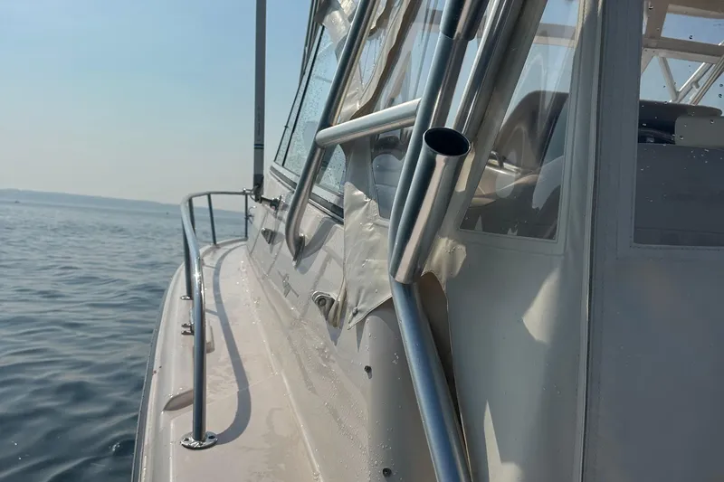 Slide: The Image of 2008 Grady White Express boat on calm water, showcasing sleek design and metal railings. - 32