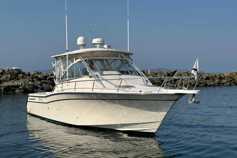 Slide: The Image of 2008 Grady White Express boat on calm water near rocky shoreline. - 4