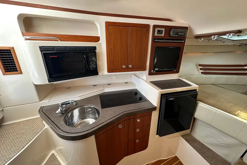 Slide: The Image of 2008 Grady White Express boat interior with kitchenette, featuring sink, microwave, and compact fridge. - 41