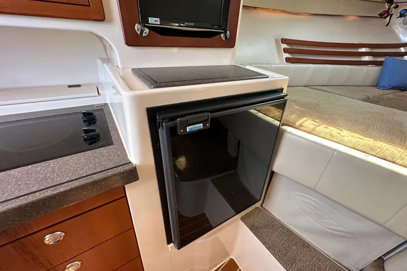 Slide: The Image of 2008 Grady White Express interior with kitchenette, fridge, and cozy seating area. - 42