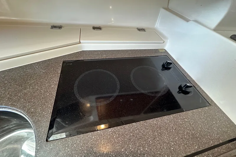 Slide: The Image of 2008 Grady White Express boat kitchen with electric stovetop and sleek countertop. - 45