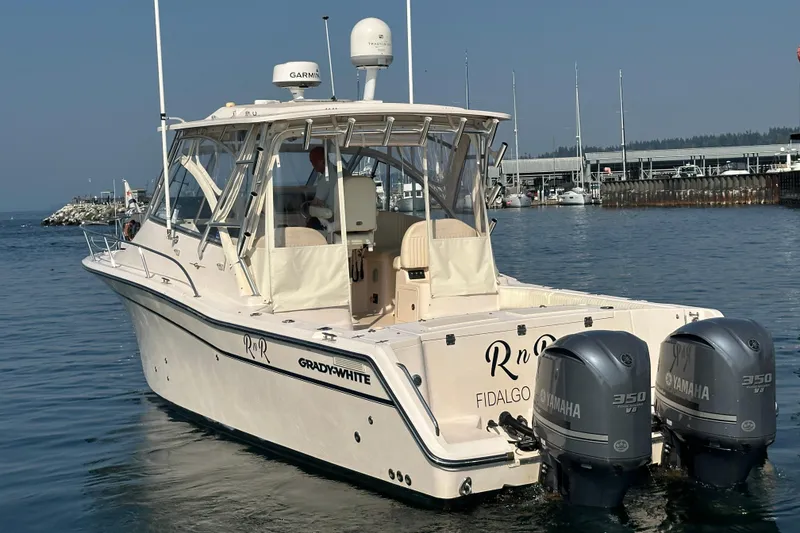 Slide: The Image of 2008 Grady White Express boat with twin Yamaha 350 engines in a marina setting. - 5