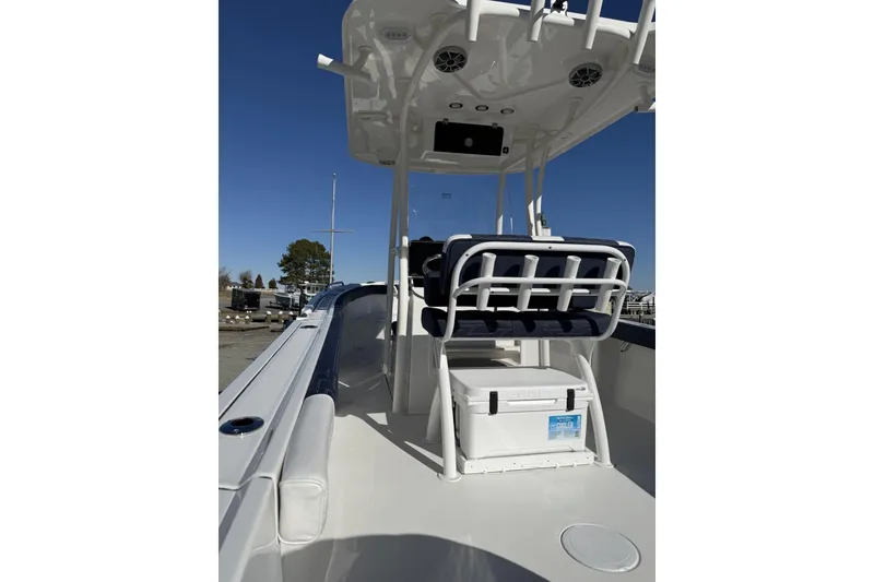 Slide: The Image of 2026 Parker 230 Coastal Elite boat interior with seating and storage, under clear blue sky. - 2