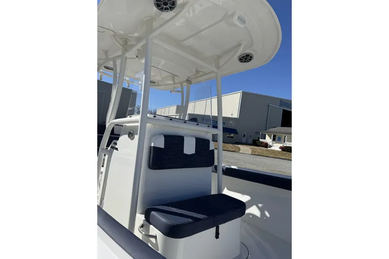 Slide: The Image of 2026 Parker 230 Coastal Elite boat interior with seating and T-top under clear sky. - 6