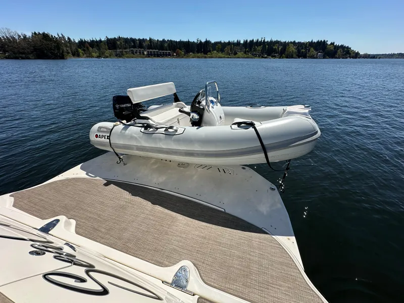 Slide: The Image of 2004 Sea Ray 340 Sundancer with inflatable boat on calm lake. - 10