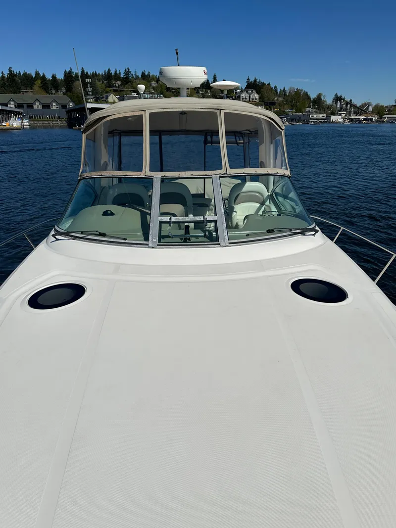 Slide: The Image of 2004 Sea Ray 340 Sundancer yacht on calm water, clear sky background. - 16