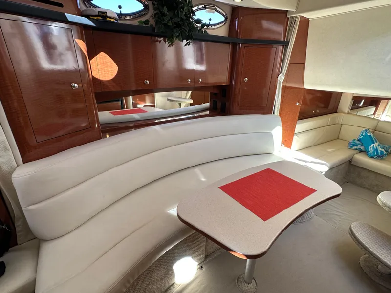 Slide: The Image of Luxurious interior of 2004 Sea Ray 340 Sundancer with white seating and wooden cabinetry. - 32