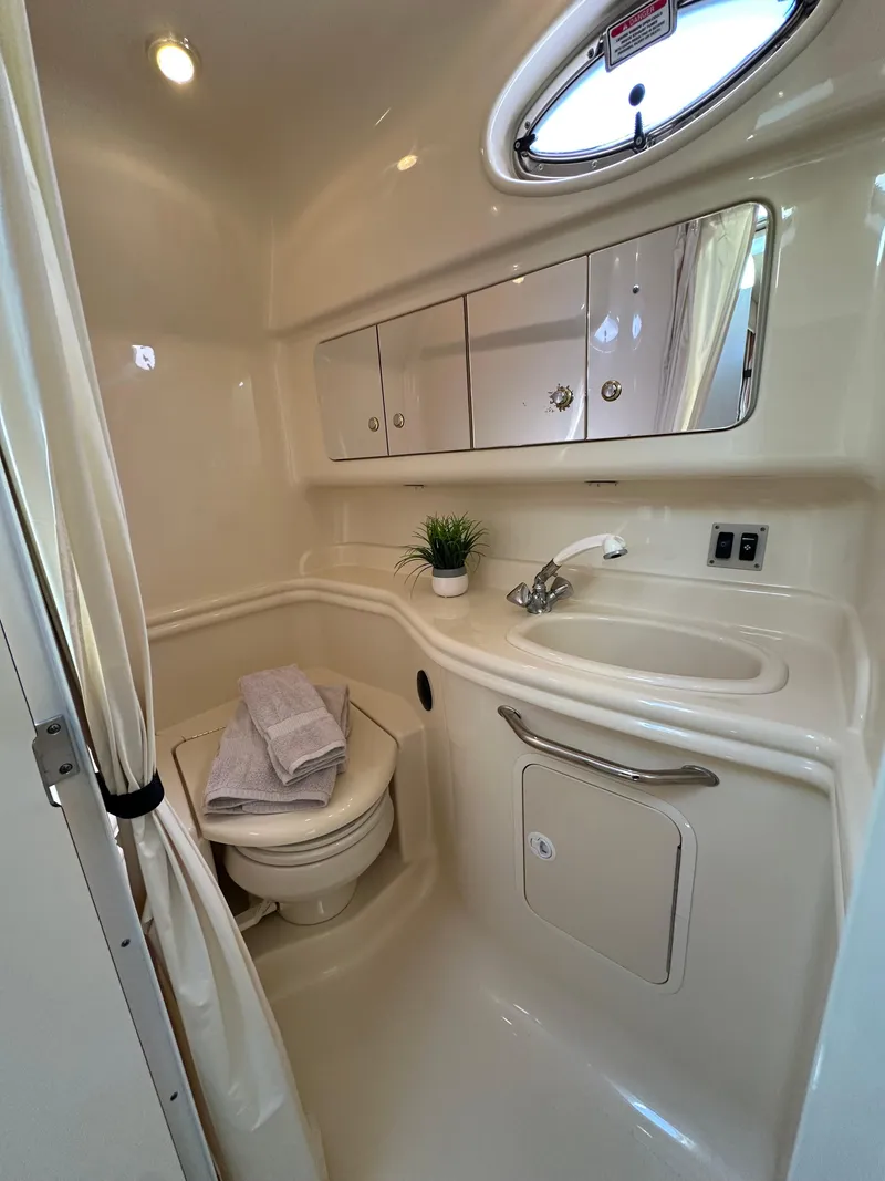 Slide: The Image of 2004 Sea Ray 340 Sundancer bathroom with sink, mirror, and porthole window. - 33