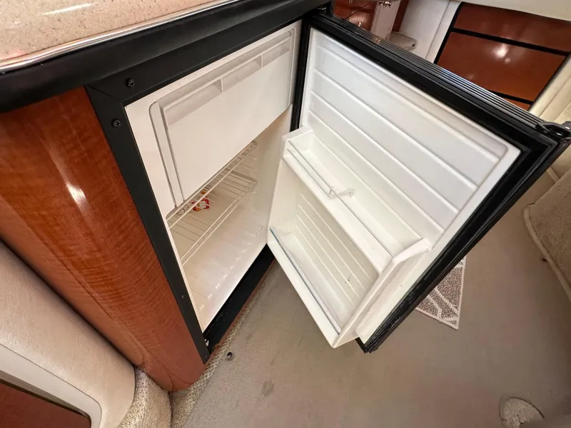 Slide: The Image of Open refrigerator inside 2004 Sea Ray 340 Sundancer yacht, showcasing interior storage space. - 38