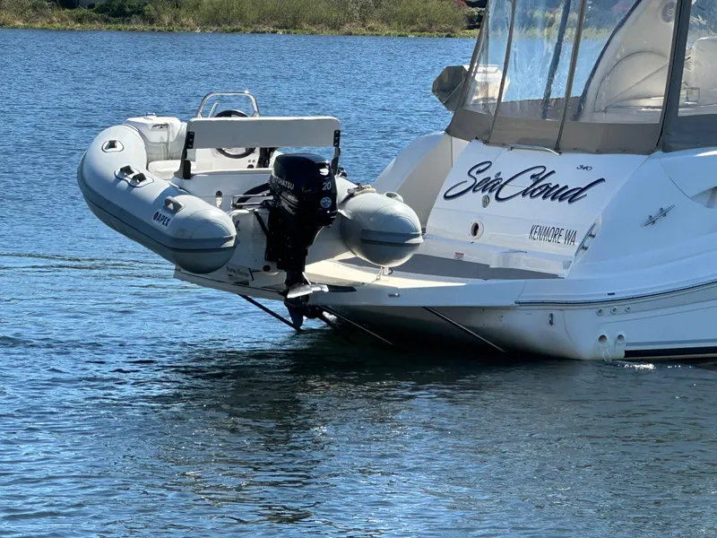 Slide: The Image of 2004 Sea Ray 340 Sundancer yacht with attached inflatable boat on calm water. - 8