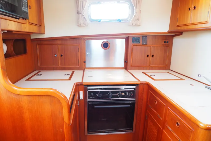 Slide: The Image of 1995 Grand Banks 38 Eastbay EX yacht kitchen with wood cabinetry and modern appliances. - 10