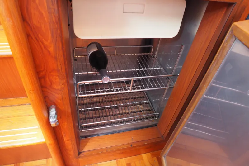 Slide: The Image of Wine bottle in a wooden cabinet fridge on a 1995 Grand Banks 38 Eastbay EX yacht. - 13
