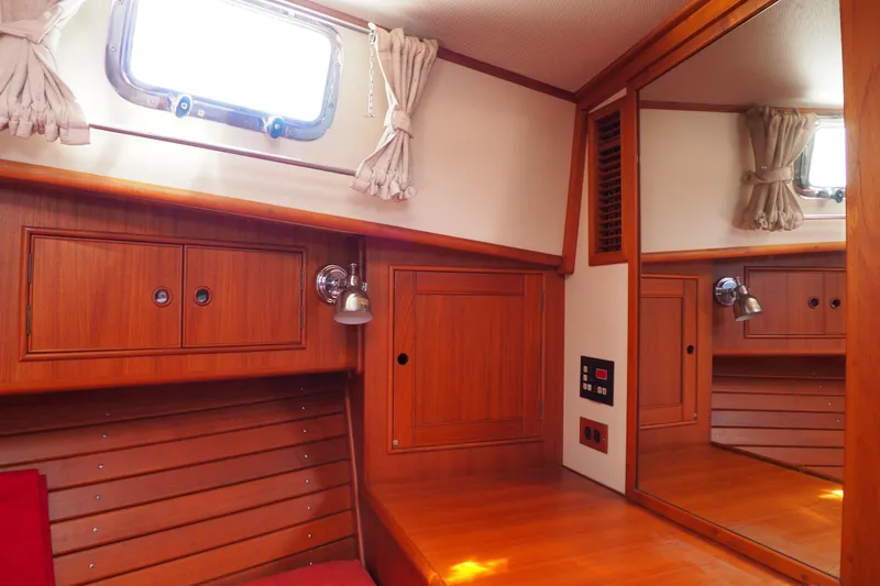 Slide: The Image of Cozy cabin interior of 1995 Grand Banks 38 Eastbay EX with wood paneling and porthole window. - 18