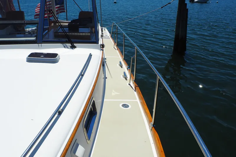 Slide: The Image of 1995 Grand Banks 38 Eastbay EX yacht deck with railing, docked on calm water. - 24