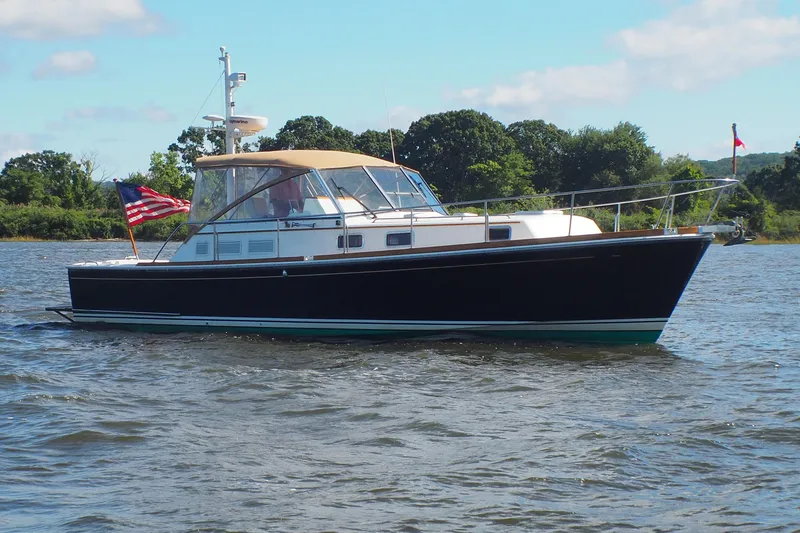Slide: The Image of 1995 Grand Banks 38 Eastbay EX yacht on calm water, American flag waving. - 34