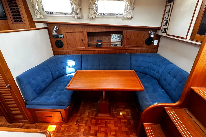 Slide: The Image of 1995 Grand Banks 38 Eastbay EX interior with blue seating and wooden table. - 4