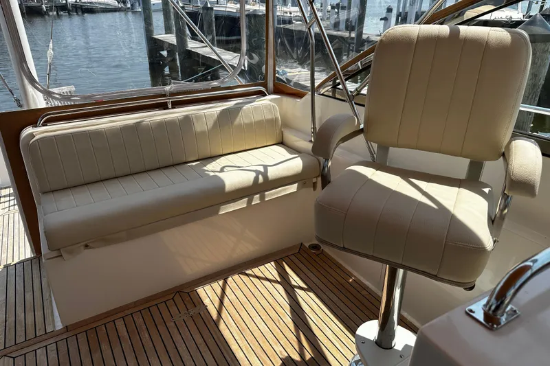 Slide: The Image of Interior seating of 1995 Grand Banks 38 Eastbay EX yacht, featuring beige upholstery and wooden flooring. - 6