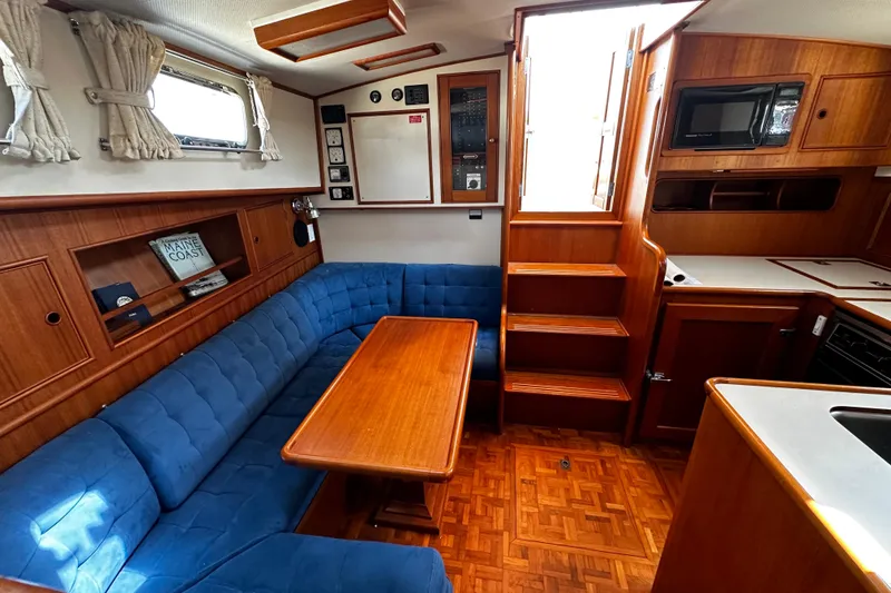 Slide: The Image of Interior of 1995 Grand Banks 38 Eastbay EX with blue seating and wooden finishes. - 9