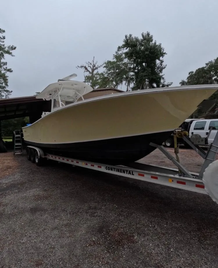 The Image of 2013 Regulator 34 Center Console boat on trailer, parked outdoors. - 0