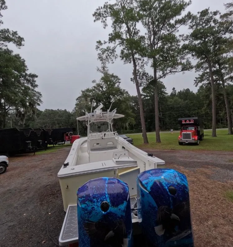 Slide: The Image of 2013 Regulator 34 Center Console boat with twin blue outboard motors in a wooded area. - 19