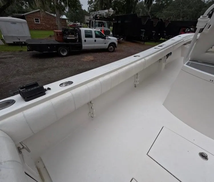 Slide: The Image of 2013 Regulator 34 Center Console boat interior with white seating and storage compartments. - 26