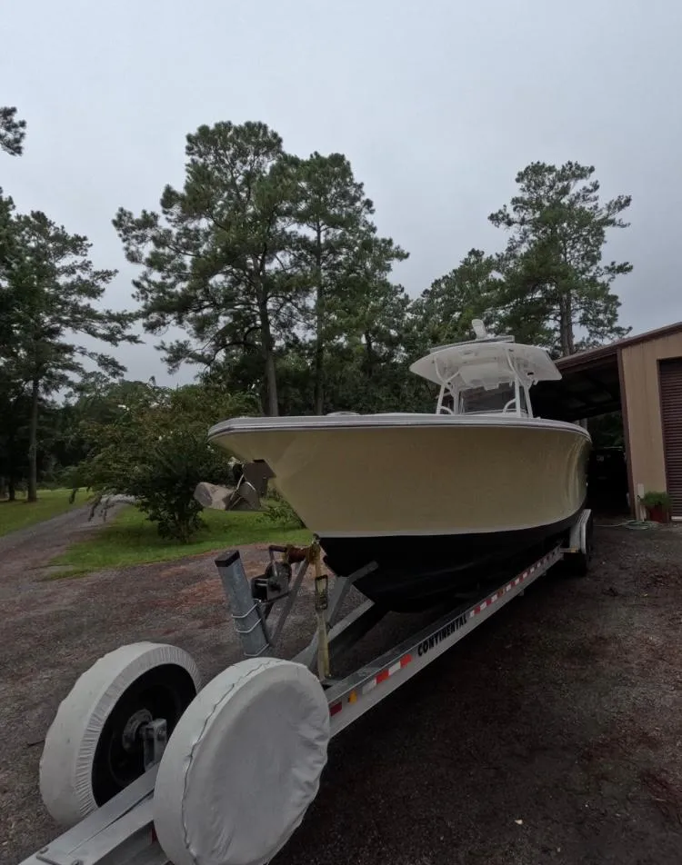 Slide: The Image of 2013 Regulator 34 Center Console boat on trailer, surrounded by trees. - 3
