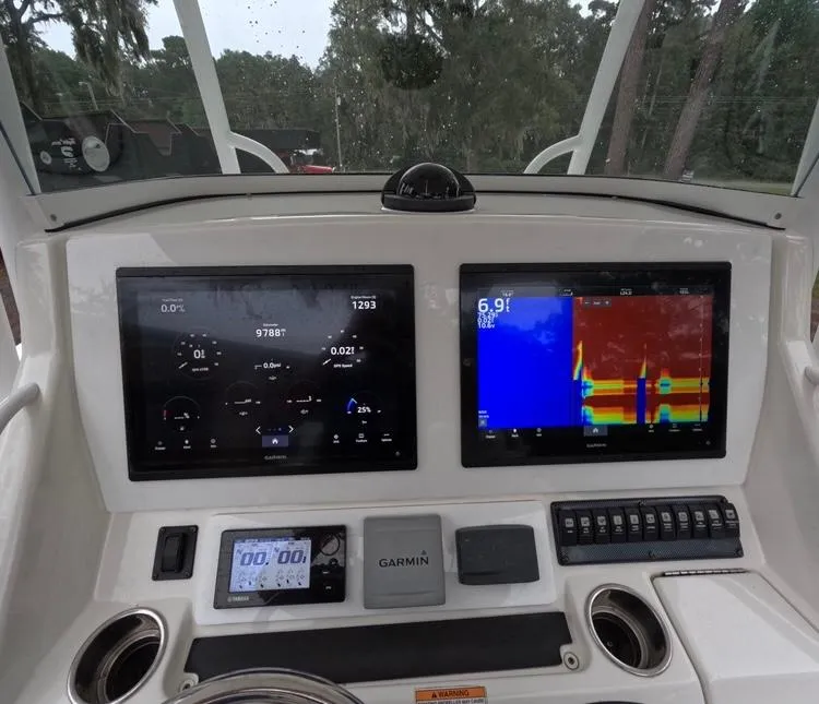 Slide: The Image of 2013 Regulator 34 Center Console dashboard with dual Garmin displays and controls. - 32