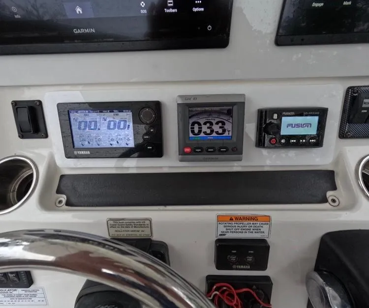 Slide: The Image of 2013 Regulator 34 Center Console dashboard with Garmin, Yamaha, and Fusion displays. - 36