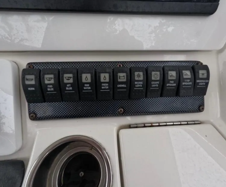 Slide: The Image of Control panel of a 2013 Regulator 34 Center Console boat with labeled switches. - 37