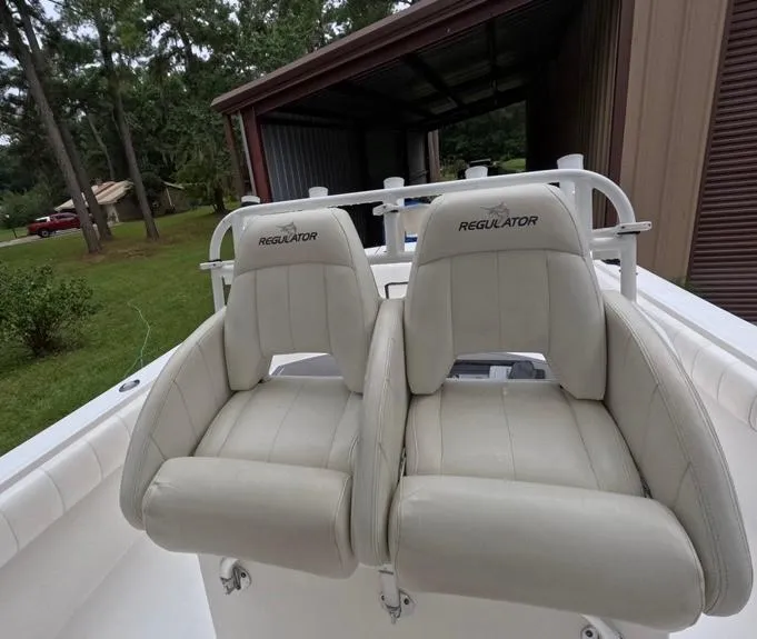 Slide: The Image of 2013 Regulator 34 Center Console boat seats, beige leather, outdoor setting. - 39