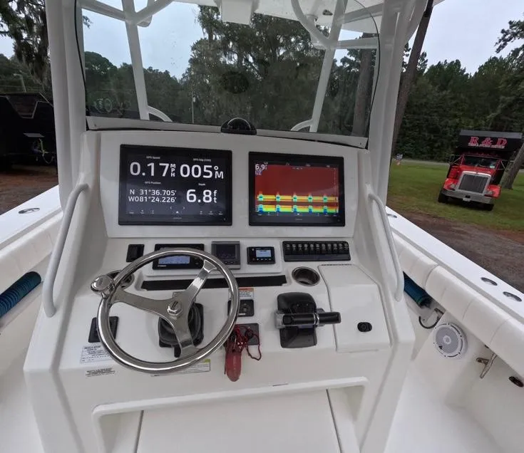 Slide: The Image of 2013 Regulator 34 Center Console boat dashboard with navigation screens and steering wheel. - 40