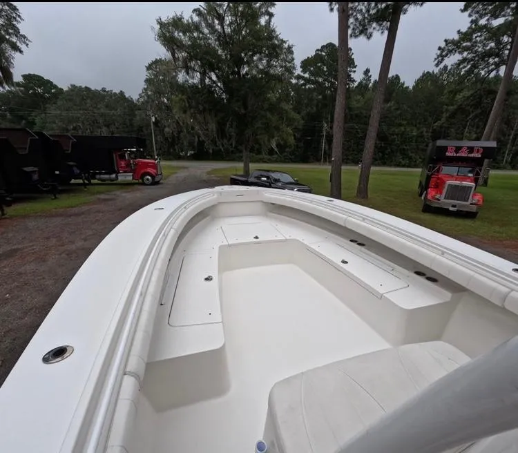 Slide: The Image of 2013 Regulator 34 Center Console boat on land, surrounded by trees and trucks. - 43