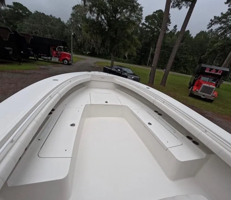 Slide: The Image of 2013 Regulator 34 Center Console boat on land, surrounded by trucks and trees. - 44