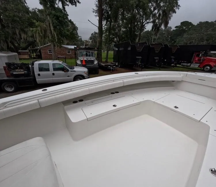 Slide: The Image of 2013 Regulator 34 Center Console boat interior with parked trucks in the background. - 45
