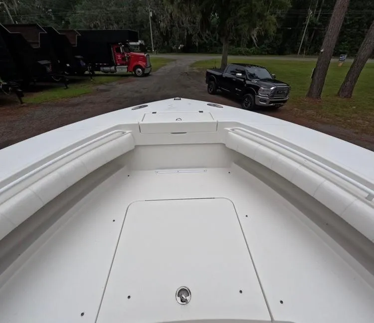 Slide: The Image of 2013 Regulator 34 Center Console boat with spacious deck, parked near trucks. - 46