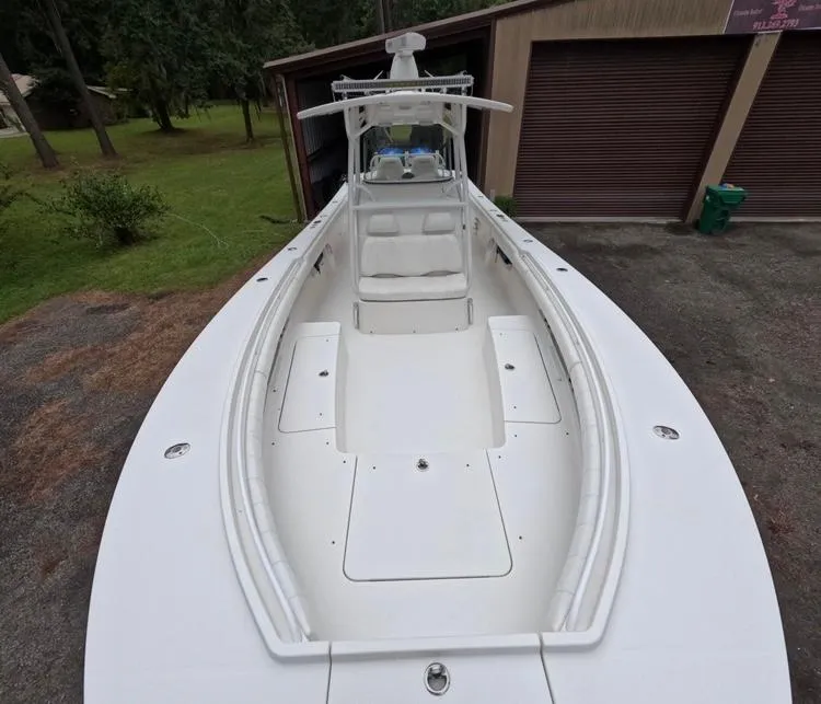 Slide: The Image of 2013 Regulator 34 Center Console boat parked near a garage. - 49