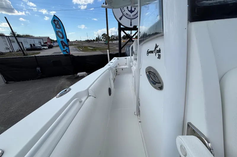 Slide: The Image of 2018 Sea Hunt Gamefish 30 Forward Seating boat, side view, showcasing sleek design and branding. - 112