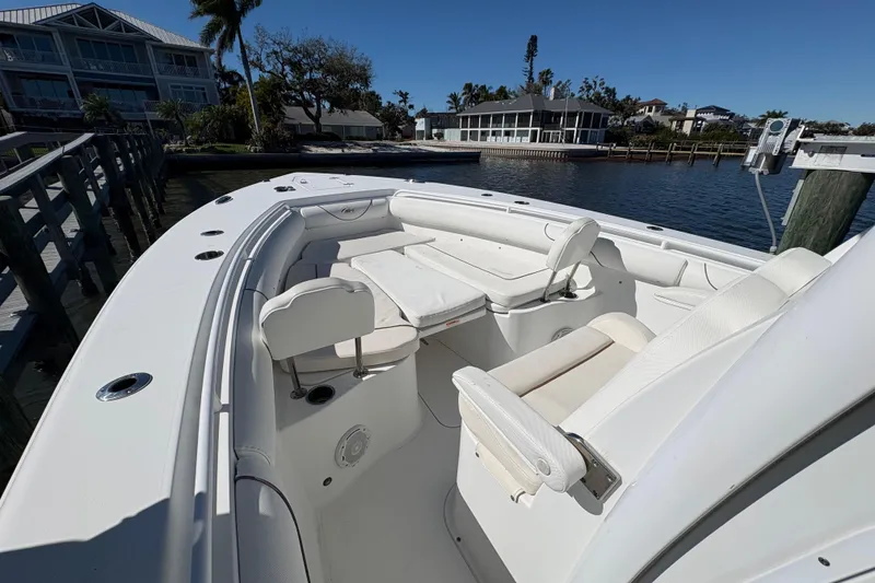 Slide: The Image of 2018 Sea Hunt Gamefish 30 boat with forward seating at a dock, under clear blue skies. - 13