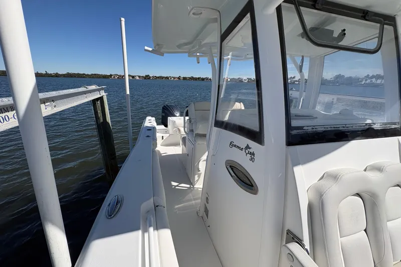 Slide: The Image of 2018 Sea Hunt Gamefish 30 boat with dual engines, docked by the water. - 20