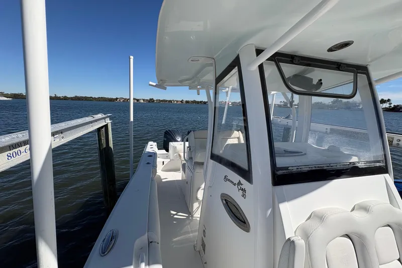 Slide: The Image of 2018 Sea Hunt Gamefish 30 boat with open storage compartment, docked by the water. - 21
