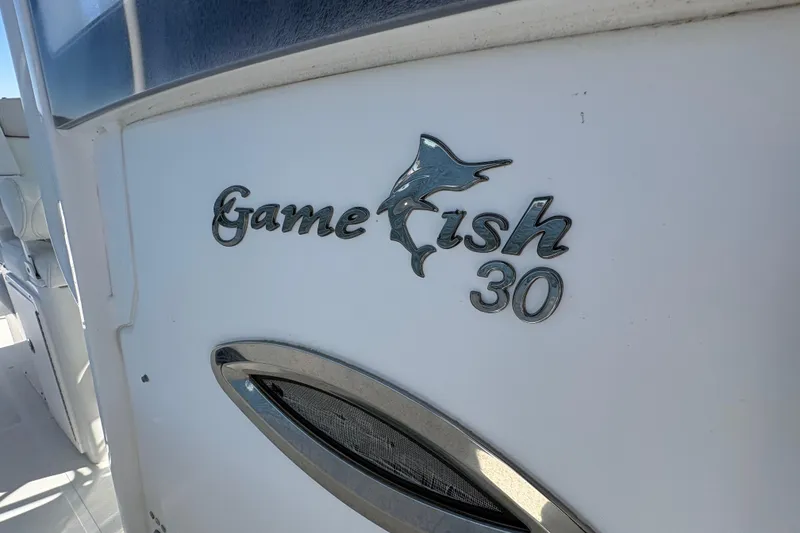 Slide: The Image of 2018 Sea Hunt Gamefish 30 boat with forward seating, docked by the water. - 22